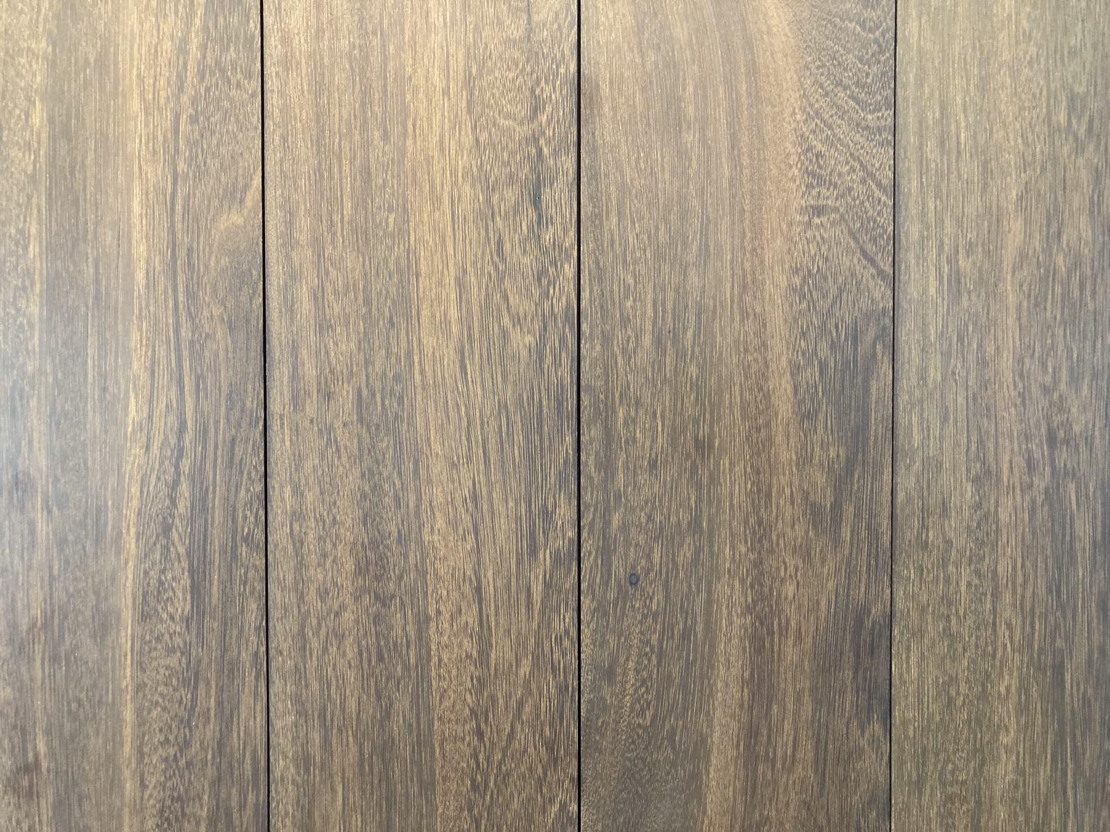 Close-up of finished belian (ulin) boards laid side by side, showing fine even grain and a deep olive-brown colour